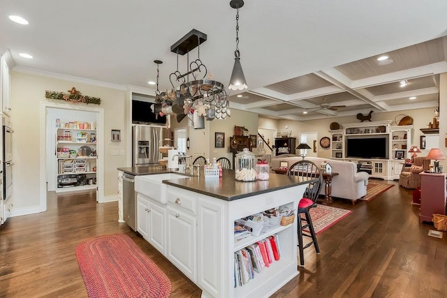 10309 S Oakcrest Ln, Olathe, KS 66061 - kitchen featuring dark countertops, a sink, appliances with stainless steel finishes, open floor plan, and white cabinetry
