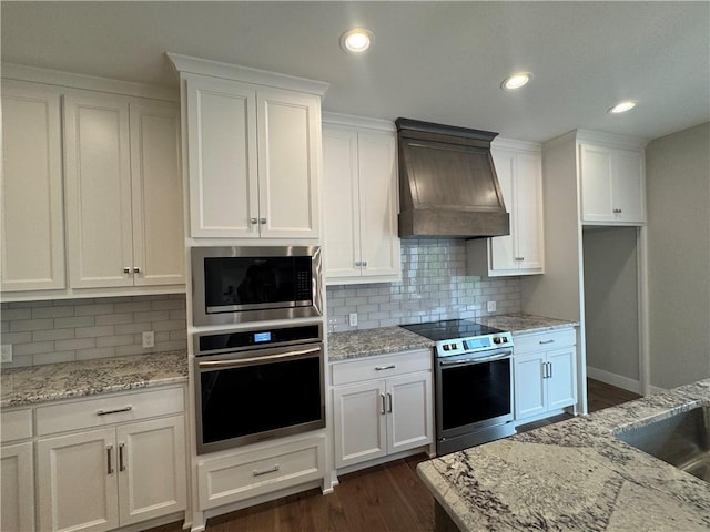 11494 S Longview Rd, Olathe, KS 66061 - kitchen with stainless steel appliances, custom range hood, white cabinetry, tasteful backsplash, and recessed lighting
