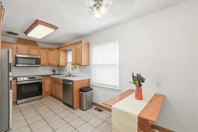 6014 Kentucky Rd, Raytown, MO 64133 - kitchen with appliances with stainless steel finishes, a sink, tasteful backsplash, light tile patterned floors, and light countertops