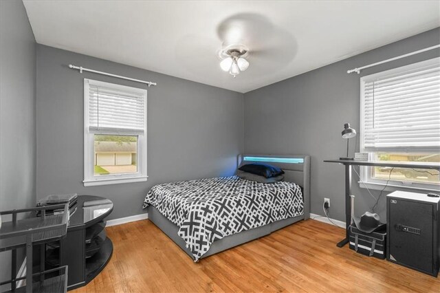 6014 Kentucky Rd, Raytown, MO 64133 - bedroom with multiple windows, baseboards, and wood finished floors
