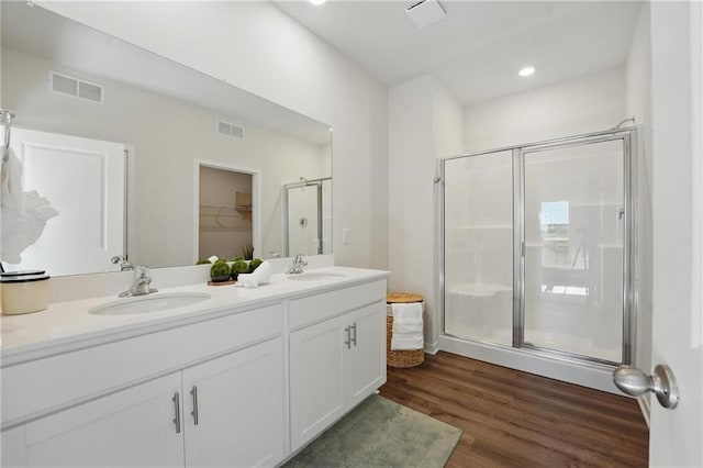 24810 178th Ct, Gardner, KS 66030 - bathroom featuring a stall shower, wood finished floors, double vanity, a walk in closet, and recessed lighting