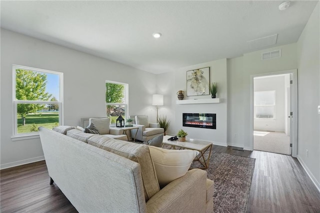 24810 178th Ct, Gardner, KS 66030 - living area featuring dark wood-type flooring, baseboards, a glass covered fireplace, and recessed lighting