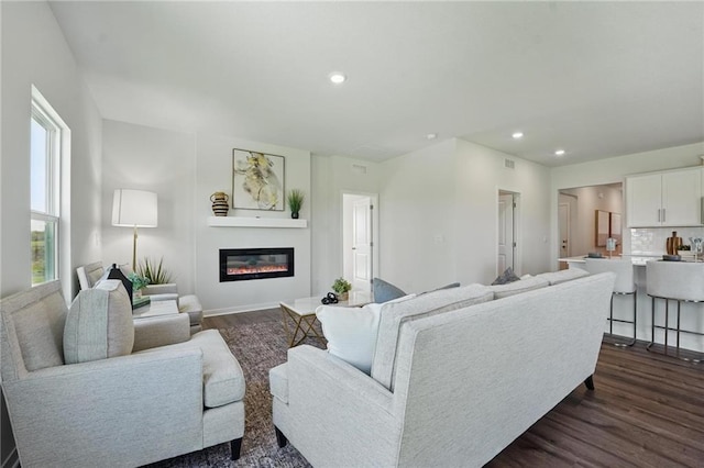24810 178th Ct, Gardner, KS 66030 - living area with dark wood-style flooring, a glass covered fireplace, recessed lighting, and baseboards