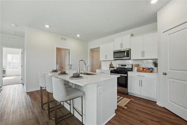 24810 178th Ct, Gardner, KS 66030 - kitchen featuring stainless steel appliances, a sink, a center island with sink, backsplash, and white cabinetry