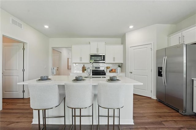 24810 178th Ct, Gardner, KS 66030 - kitchen with appliances with stainless steel finishes, a breakfast bar area, light countertops, white cabinets, and recessed lighting