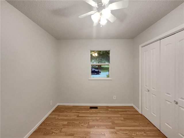 131 Brookridge St, Lansing, KS 66043 - unfurnished bedroom featuring light wood finished floors, a textured ceiling, a closet, baseboards, and ceiling fan