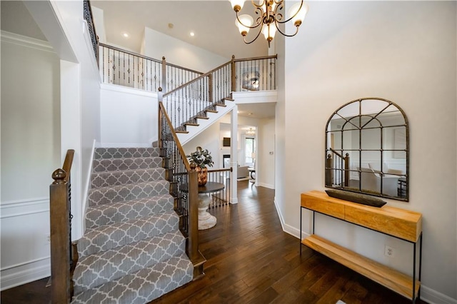 9101 W 158th St, Overland Park, KS 66221 - stairway featuring a chandelier, hardwood / wood-style flooring, baseboards, a towering ceiling, and recessed lighting