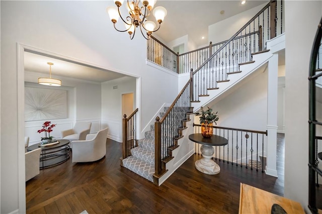 9101 W 158th St, Overland Park, KS 66221 - stairs with wood finished floors, a high ceiling, a wainscoted wall, and a chandelier