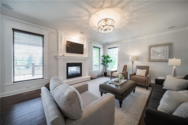 9101 W 158th St, Overland Park, KS 66221 - living area with baseboards, a chandelier, ornamental molding, a fireplace, and dark wood-style floors