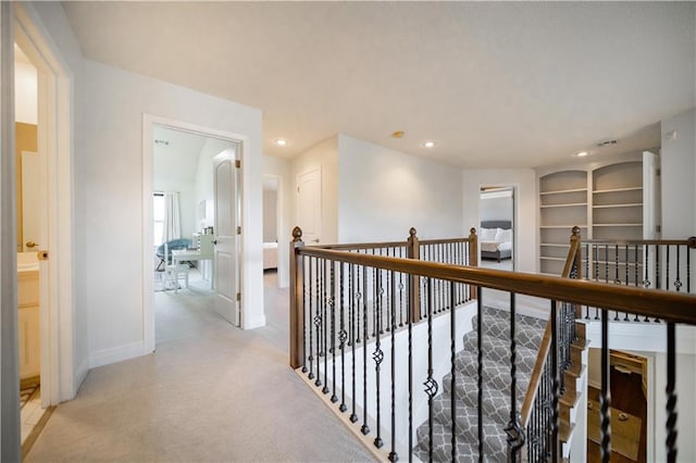 9101 W 158th St, Overland Park, KS 66221 - hallway with an upstairs landing, baseboards, light colored carpet, recessed lighting, and built in features