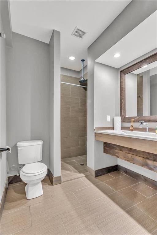 9101 W 158th St, Overland Park, KS 66221 - bathroom with toilet, baseboards, a tile shower, vanity, and recessed lighting