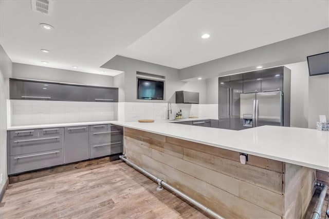 9101 W 158th St, Overland Park, KS 66221 - kitchen with gray cabinets, stainless steel fridge, modern cabinets, backsplash, and a peninsula
