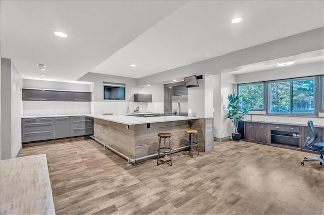 9101 W 158th St, Overland Park, KS 66221 - kitchen with stainless steel fridge with ice dispenser, light wood-type flooring, gray cabinetry, modern cabinets, and recessed lighting