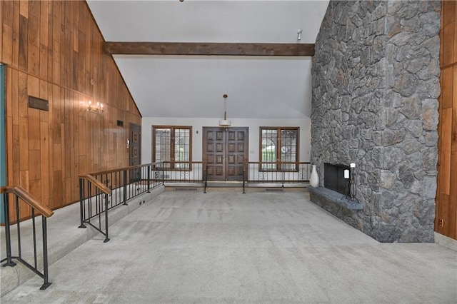 12614 Ensley Ln, Leawood, KS 66209 - unfurnished living room with carpet flooring, beam ceiling, wooden walls, high vaulted ceiling, and french doors