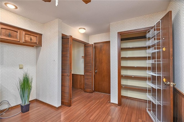 12614 Ensley Ln, Leawood, KS 66209 - hall with wallpapered walls, wood finished floors, baseboards, and wainscoting