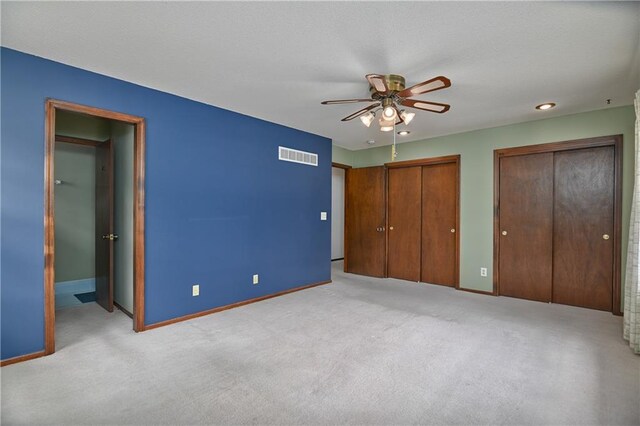 12614 Ensley Ln, Leawood, KS 66209 - unfurnished bedroom with two closets, baseboards, light carpet, and ceiling fan