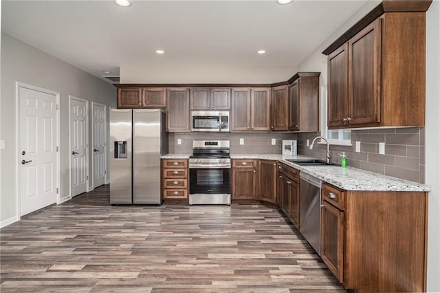 720 S Funston St, Ottawa, KS 66067 - kitchen with appliances with stainless steel finishes, a sink, wood finished floors, backsplash, and recessed lighting