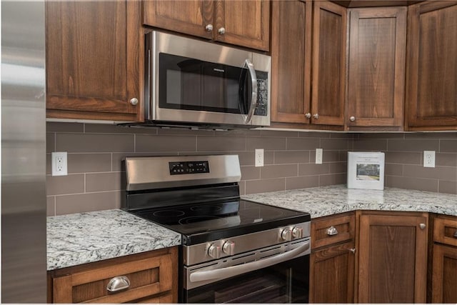720 S Funston St, Ottawa, KS 66067 - kitchen with stainless steel appliances, decorative backsplash, and light stone countertops