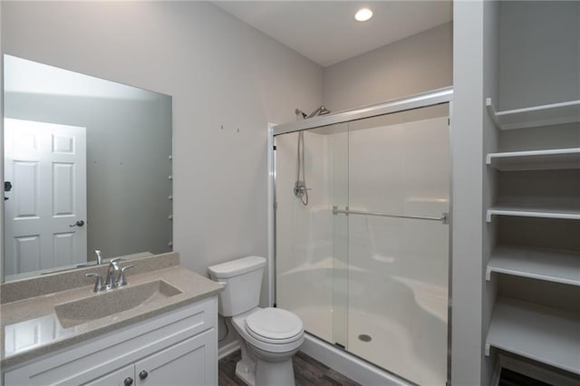 720 S Funston St, Ottawa, KS 66067 - bathroom featuring a stall shower, vanity, toilet, wood finished floors, and recessed lighting