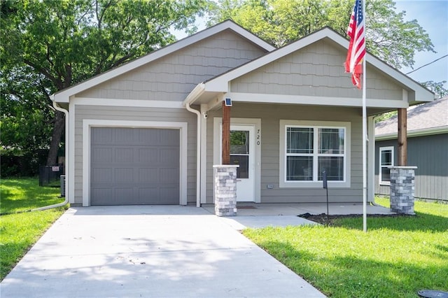 720 S Funston St, Ottawa, KS 66067 - view of front of house featuring a garage, a porch, a front yard, and driveway