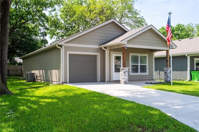 720 S Funston St, Ottawa, KS 66067 - view of front of home with an attached garage, a front yard, concrete driveway, and central AC