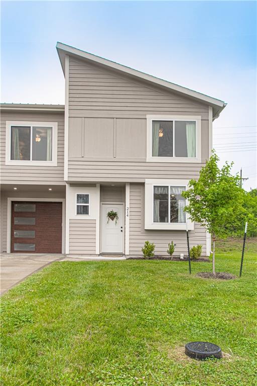 214 N Mcgee St, Tonganoxie, KS 66086 - view of front facade with a garage, a front lawn, and concrete driveway