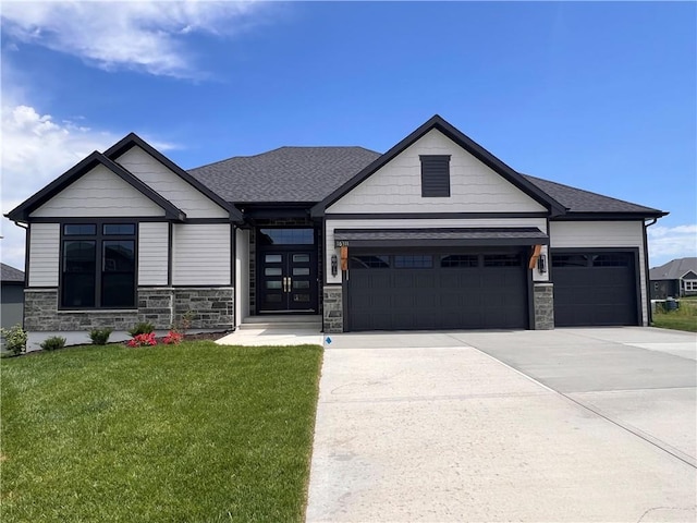 16311 Mustang St, Gardner, KS 66030 - view of front of house featuring stone siding, a garage, driveway, and a front yard