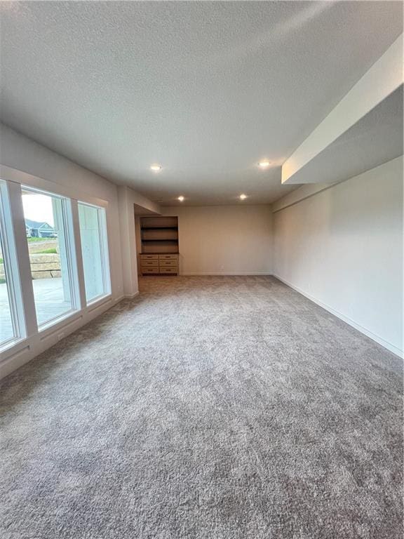 16311 Mustang St, Gardner, KS 66030 - unfurnished living room featuring carpet floors, a textured ceiling, recessed lighting, and baseboards