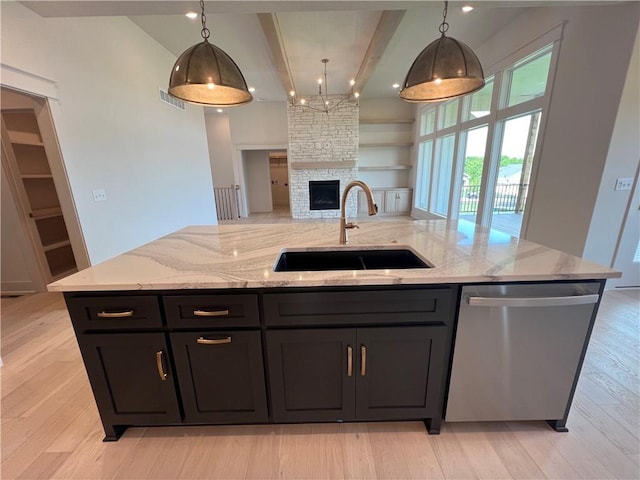 16311 Mustang St, Gardner, KS 66030 - kitchen with stainless steel dishwasher, a sink, open floor plan, beamed ceiling, and light stone countertops