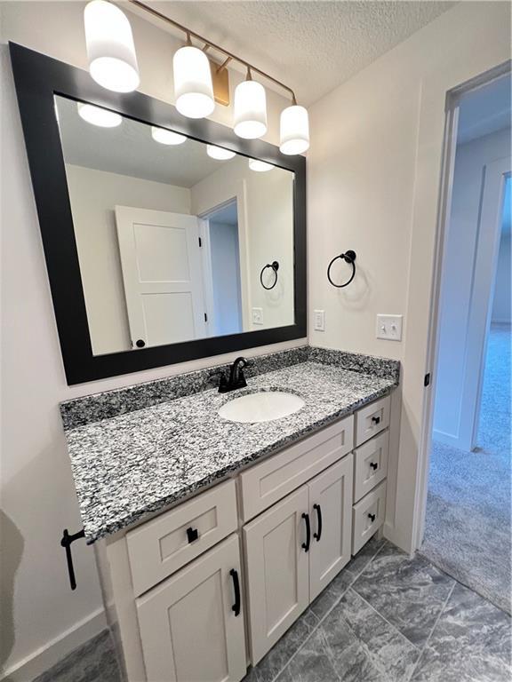 16311 Mustang St, Gardner, KS 66030 - bathroom featuring vanity, a textured ceiling, and baseboards