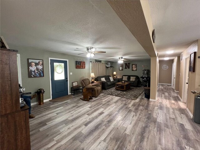 344 E 520th Ave, Pittsburg, KS 66762 - living area with a textured ceiling, light wood finished floors, a ceiling fan, baseboards, and a barn door