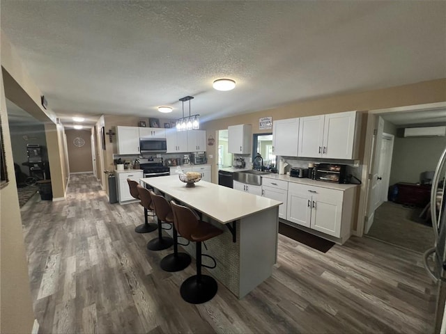 344 E 520th Ave, Pittsburg, KS 66762 - kitchen with appliances with stainless steel finishes, dark wood-style floors, a center island, a breakfast bar, and a sink