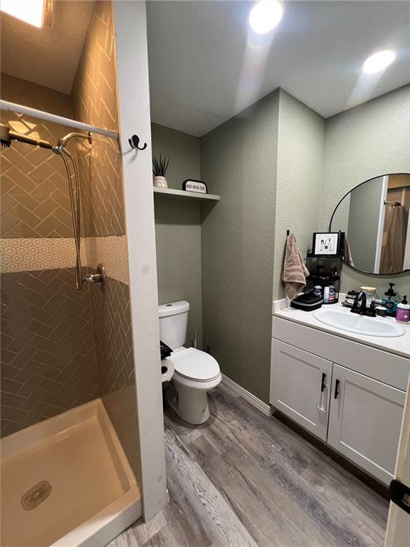 344 E 520th Ave, Pittsburg, KS 66762 - bathroom featuring a stall shower, vanity, toilet, and wood finished floors