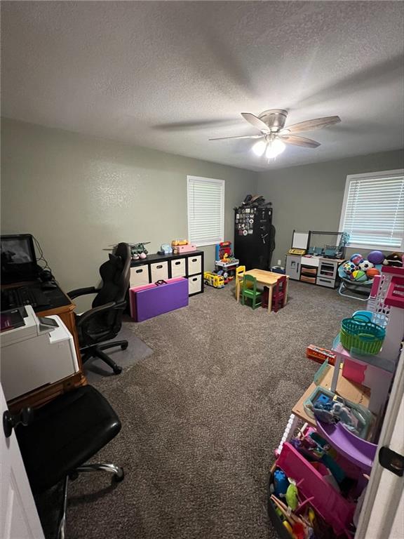 344 E 520th Ave, Pittsburg, KS 66762 - rec room featuring a textured ceiling, carpet floors, a desk, and ceiling fan
