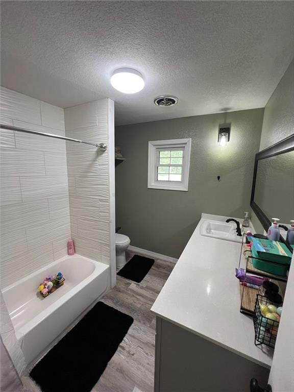 344 E 520th Ave, Pittsburg, KS 66762 - full bathroom featuring double vanity, toilet, a textured ceiling, shower / washtub combination, and wood finished floors