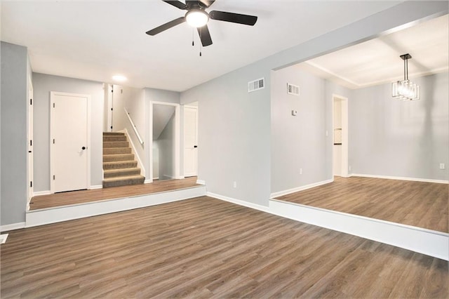 12309 Askew Dr, Grandview, MO 64030 - unfurnished living room with wood finished floors, a ceiling fan, stairway, and baseboards
