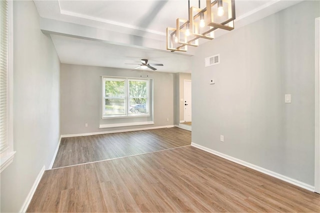 12309 Askew Dr, Grandview, MO 64030 - spare room with wood finished floors, a ceiling fan, baseboards, and a chandelier
