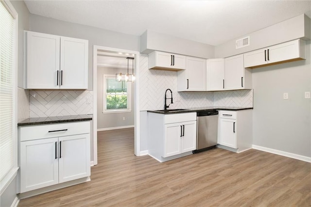 12309 Askew Dr, Grandview, MO 64030 - kitchen featuring dishwasher, a sink, dark countertops, light wood-type flooring, and white cabinets
