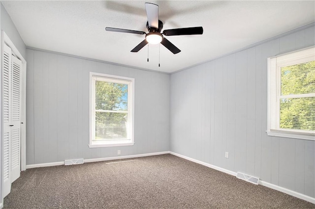 12309 Askew Dr, Grandview, MO 64030 - unfurnished bedroom with multiple windows, carpet, a closet, and ceiling fan