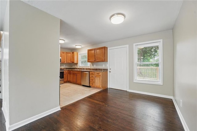 10217 Wheeling Ave, Kansas City, MO 64134 - kitchen featuring stainless steel appliances, light wood-style floors, baseboards, and a sink