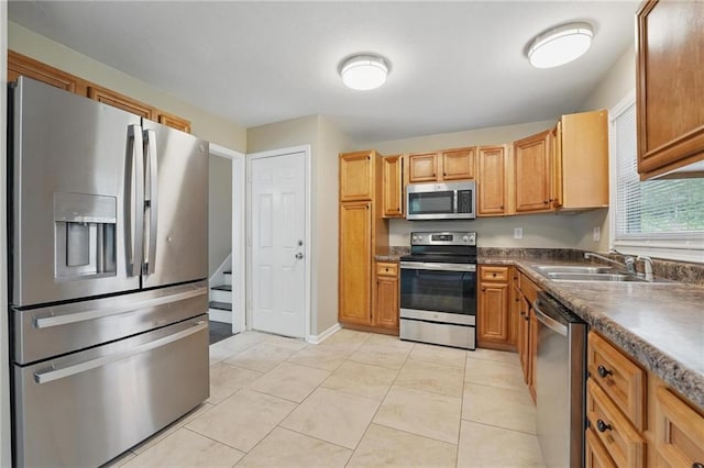 10217 Wheeling Ave, Kansas City, MO 64134 - kitchen with appliances with stainless steel finishes, a sink, dark countertops, and light tile patterned flooring