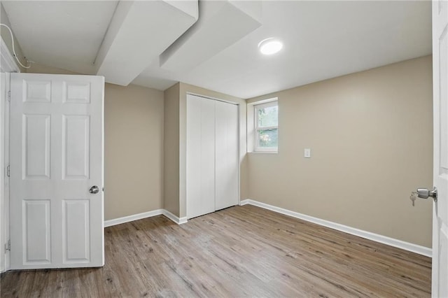 10217 Wheeling Ave, Kansas City, MO 64134 - unfurnished bedroom with baseboards, light wood-style floors, and a closet