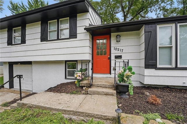 10217 Wheeling Ave, Kansas City, MO 64134 - view of exterior entry with an attached garage and brick siding