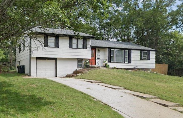 10217 Wheeling Ave, Kansas City, MO 64134 - tri-level home featuring a garage, a front lawn, and driveway