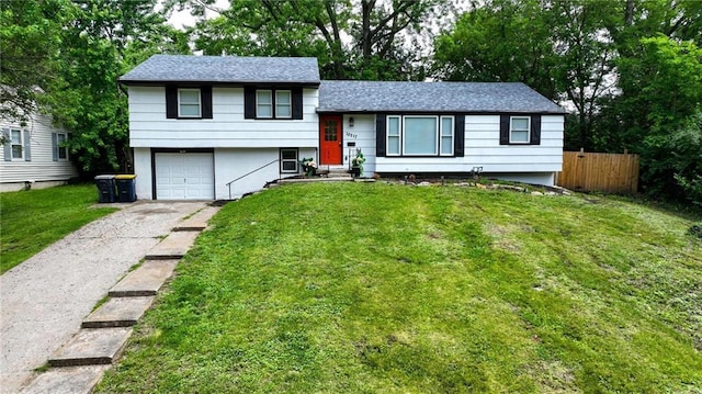 10217 Wheeling Ave, Kansas City, MO 64134 - split level home featuring driveway, an attached garage, and roof with shingles