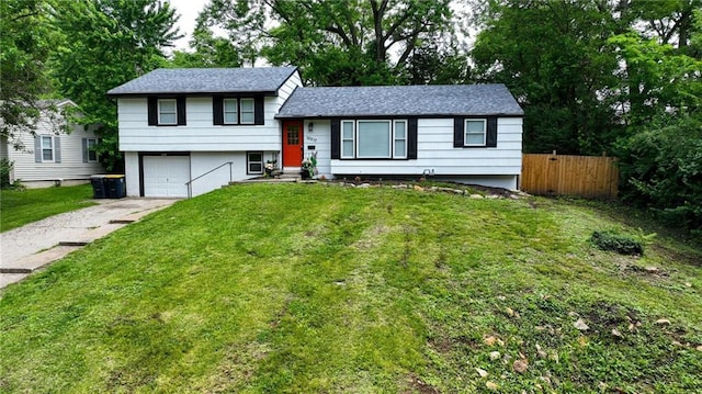 10217 Wheeling Ave, Kansas City, MO 64134 - split level home with concrete driveway, an attached garage, and a shingled roof
