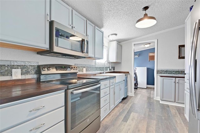 38686 Jingo Rd, Lacygne, KS 66040 - kitchen with stainless steel appliances, tasteful backsplash, a sink, light wood-style flooring, and crown molding