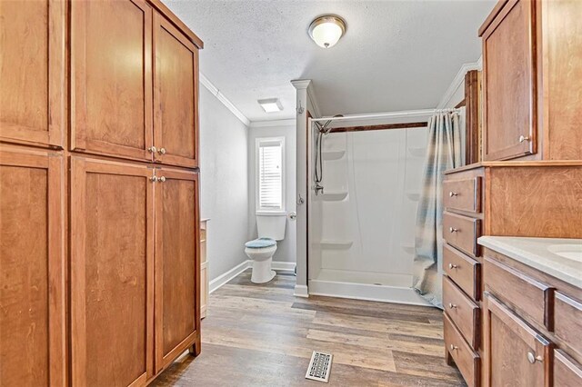 38686 Jingo Rd, Lacygne, KS 66040 - bathroom with ornamental molding, curtained shower, wood finished floors, baseboards, and toilet