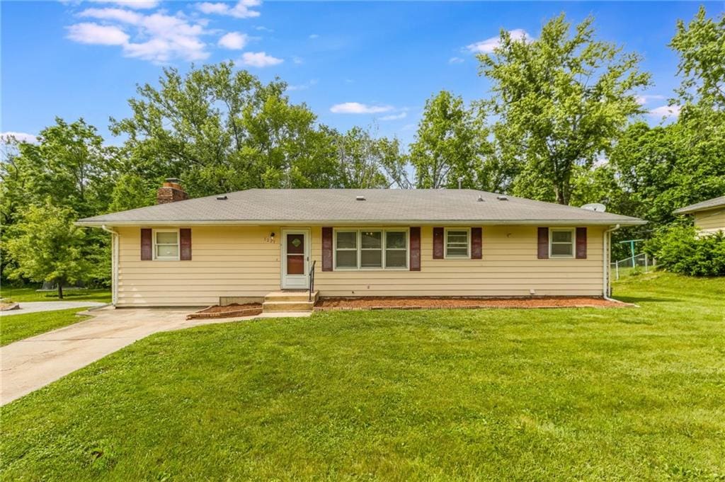 1221 Sunset St, Chillicothe, MO 64601 - ranch-style house with a chimney, a front lawn, and concrete driveway