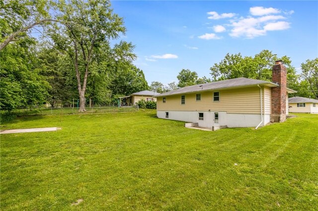 1221 Sunset St, Chillicothe, MO 64601 - rear view of property with a chimney and a lawn